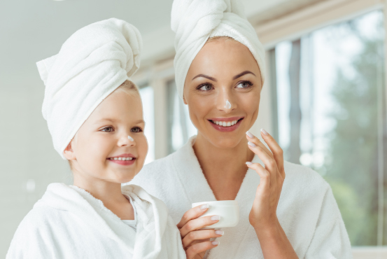 a mother and daughter with face lotion